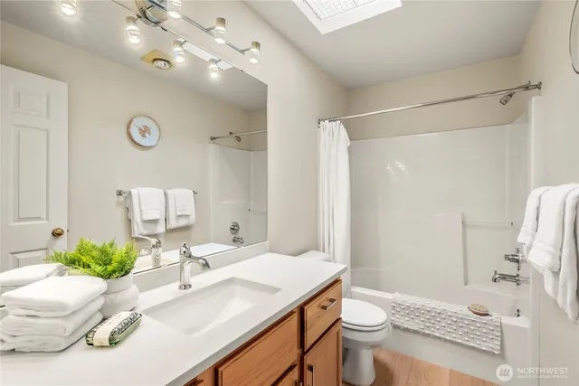 a bathroom with a sink vanity mirror and toilet
