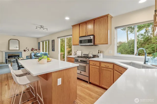 a kitchen with stainless steel appliances granite countertop a stove a sink dishwasher a stove a refrigerator with island and chairs