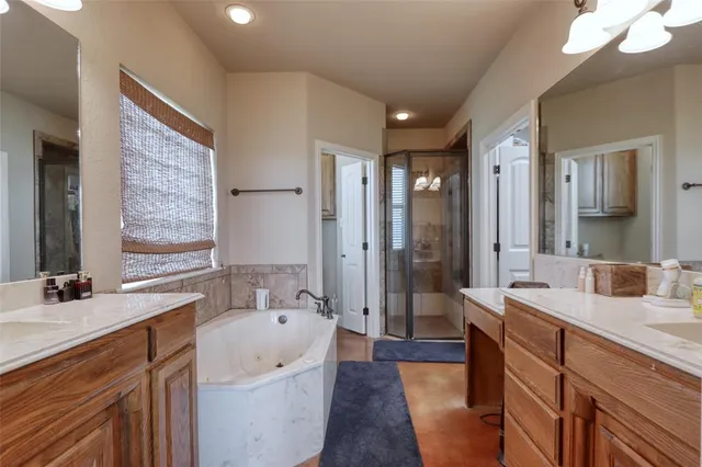 a spacious bathroom with a bathtub a sink and a large mirror