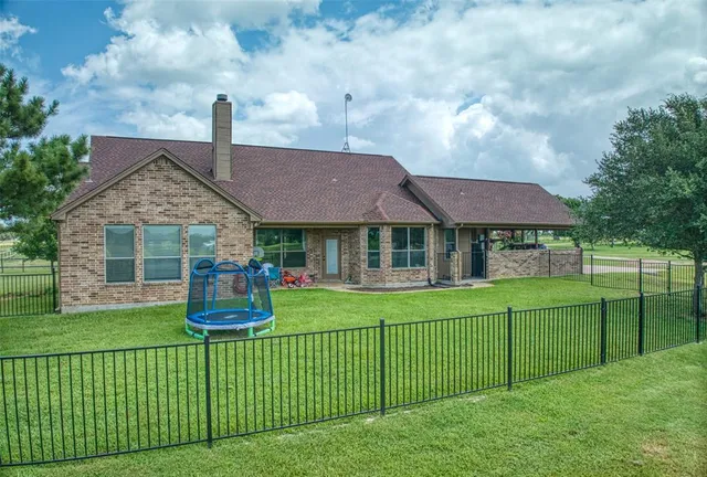 a view of a chair and table in backyard of house