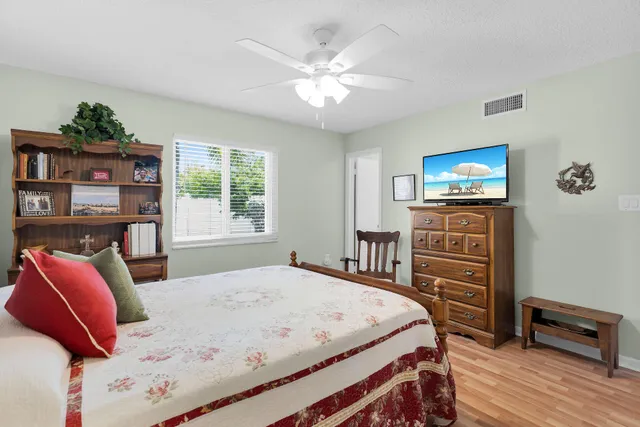 a bedroom with a bed a dresser and a painting