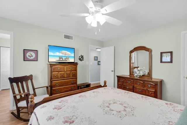 a bedroom with a bed and a dresser with mirror