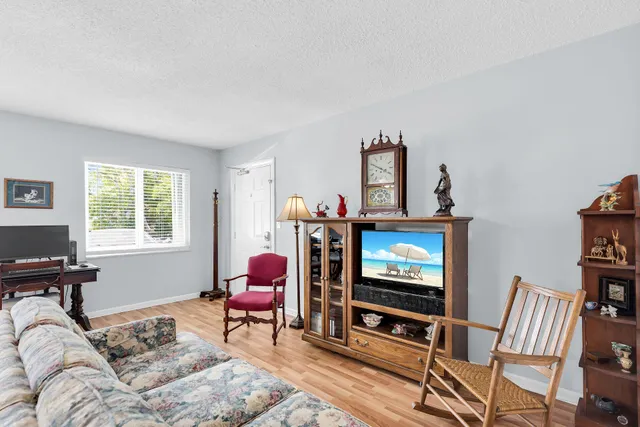 a living room with furniture a flat screen tv and a window