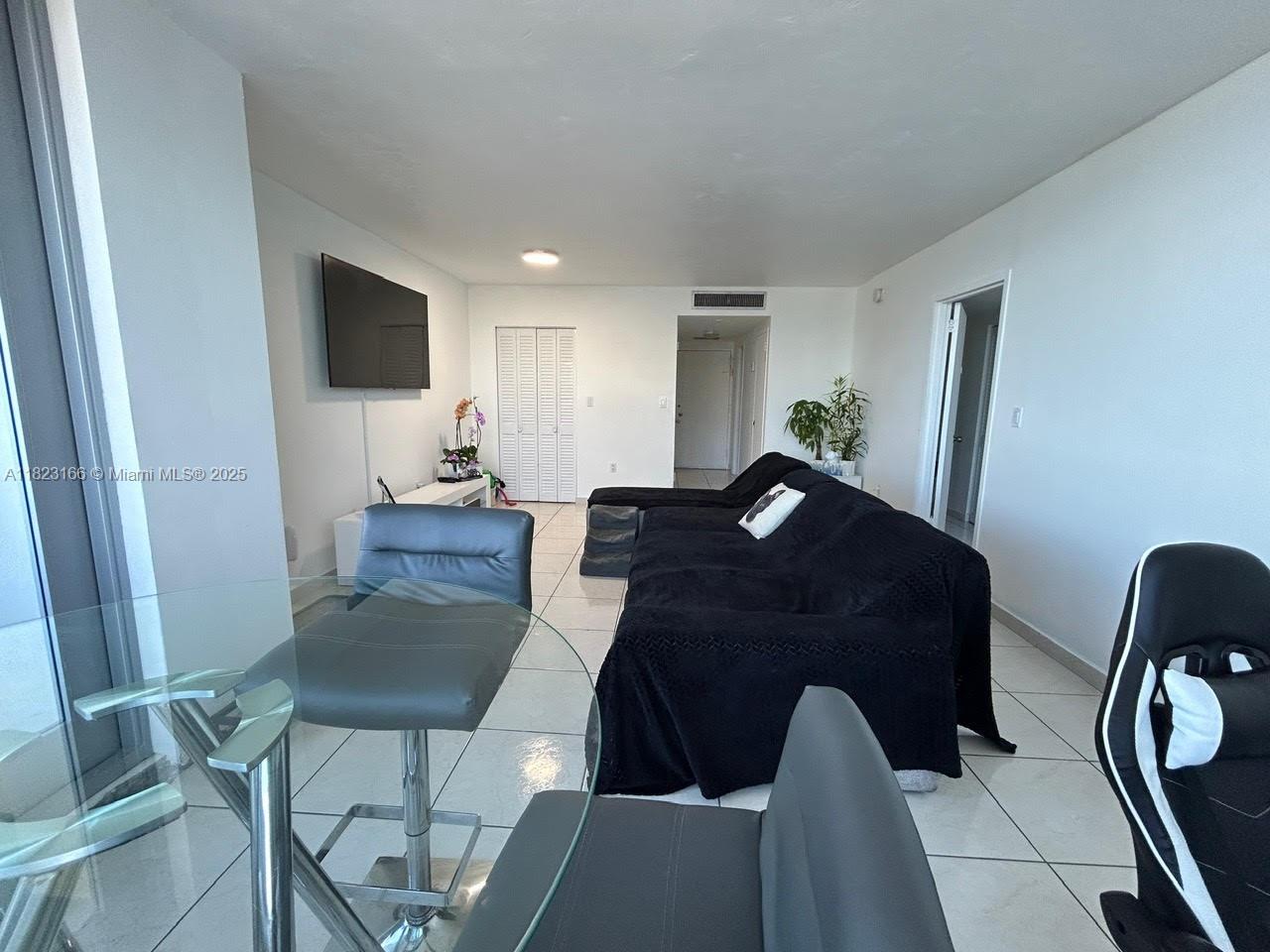 2899 Collins Avenue, Unit 1717 Miami Beach, FL 33140 - Photo 17 of 32 a living room with furniture and a flat screen tv