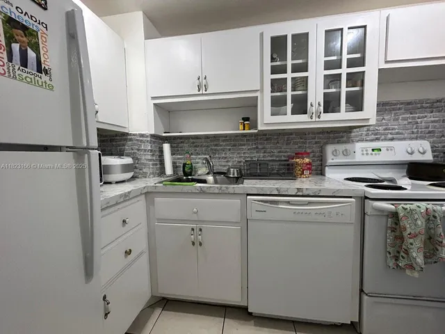 a kitchen with stainless steel appliances white cabinets and a refrigerator