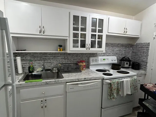 a kitchen with appliances a sink and cabinets