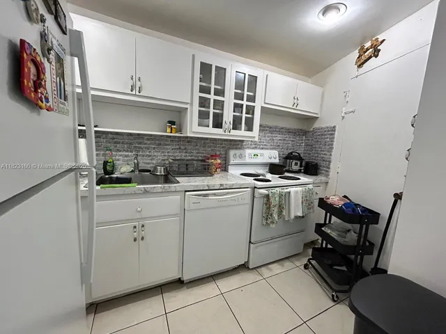 a kitchen with cabinets appliances and furniture