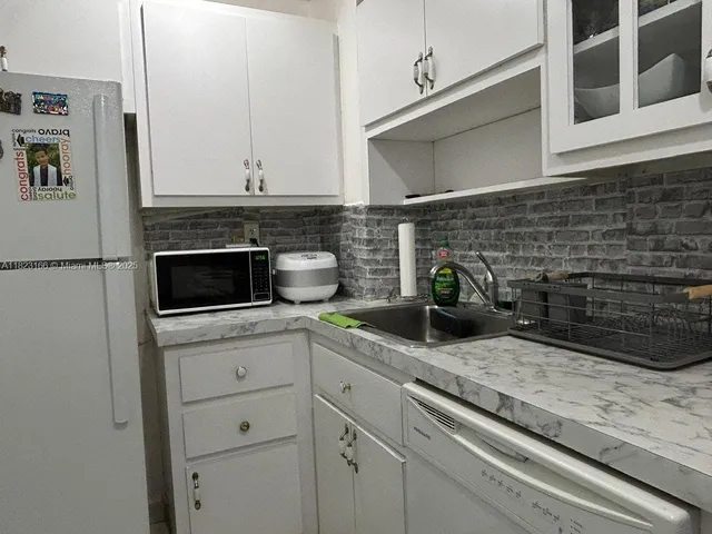 a kitchen with appliances a sink and cabinets