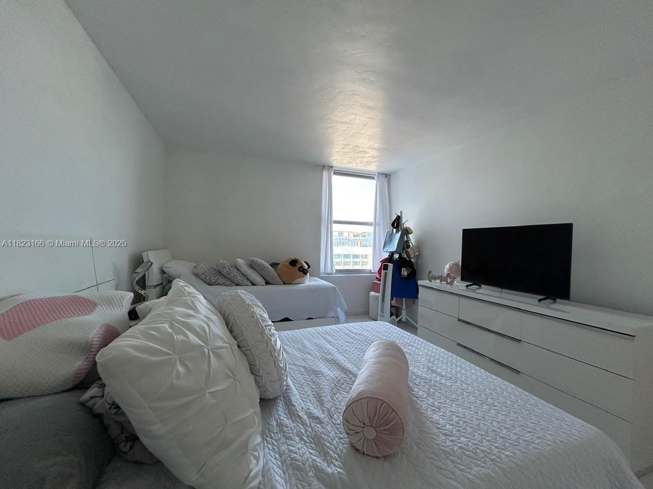 2899 Collins Avenue, Unit 1717 Miami Beach, FL 33140 - Photo 24 of 32 a living room with furniture and a flat screen tv