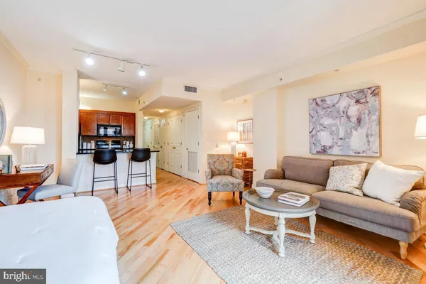 a living room with furniture and a view of kitchen