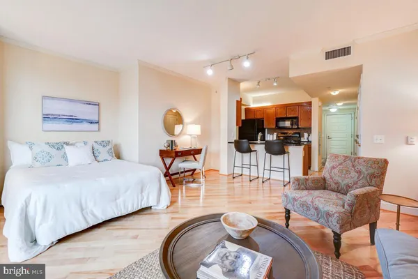 a living room with furniture a flat screen tv and kitchen view