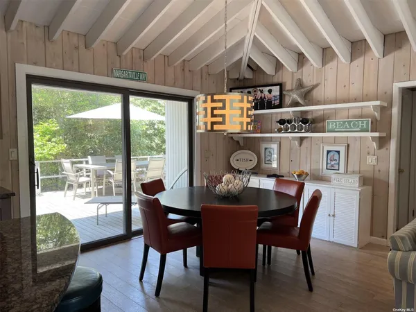 a dining room with furniture wooden floor and a floor to ceiling window