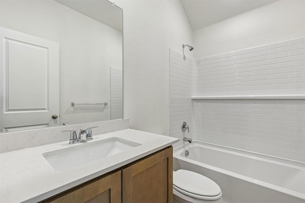 3820 Prairie Chapel Road Royse City, TX 75189 - Photo 14 of 18 a bathroom with a granite countertop sink toilet and shower