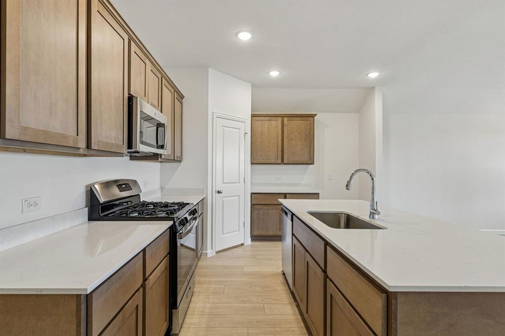 3820 Prairie Chapel Road Royse City, TX 75189 - Photo 4 of 18 a kitchen with stainless steel appliances granite countertop a sink stove and cabinets