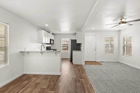 a view of open kitchen with wooden floor and a refrigerator