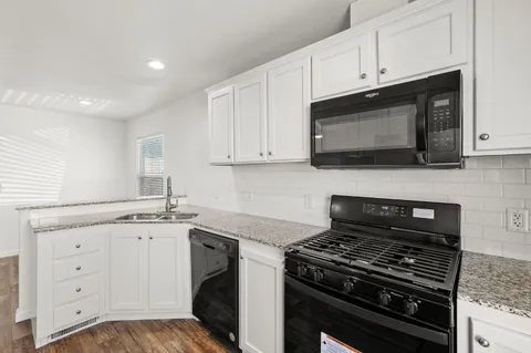 a kitchen with a refrigerator and a stove top oven
