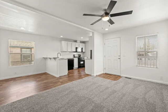 a view of an empty room with kitchen appliances and a window