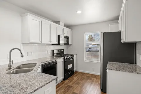 a kitchen with stainless steel appliances granite countertop a refrigerator and a stove