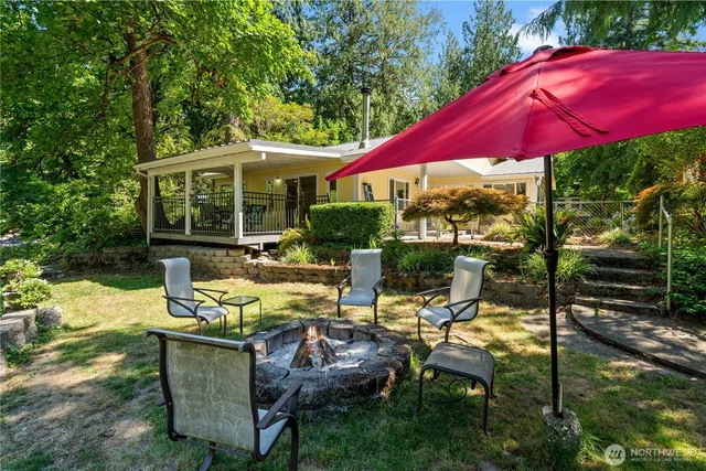 a view of a patio with chairs and table under an umbrella
