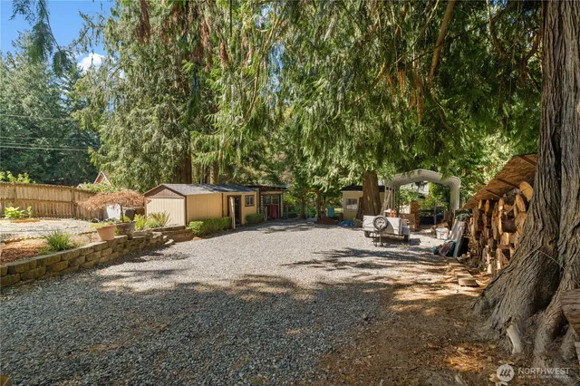 a backyard of a house with table and chairs under an umbrella