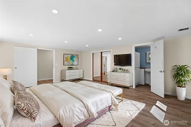 a bedroom with a large bed a flat screen tv and a couch