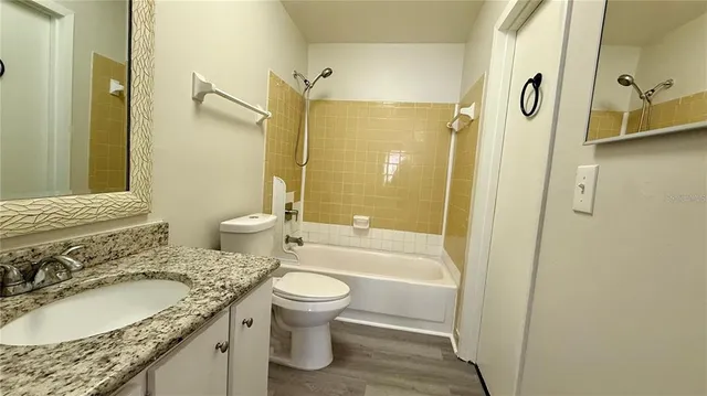 a bathroom with a granite countertop toilet sink and shower