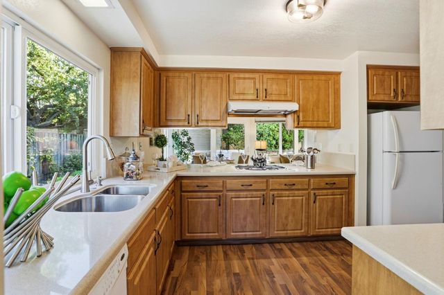 a kitchen with kitchen island granite countertop a sink a counter space and stainless steel appliances