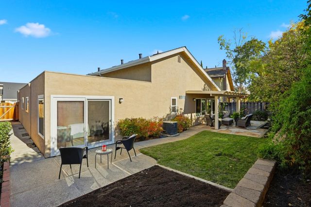 a view of a house with backyard sitting area and garden