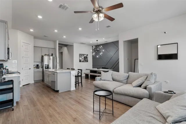a living room with furniture and a wooden floor