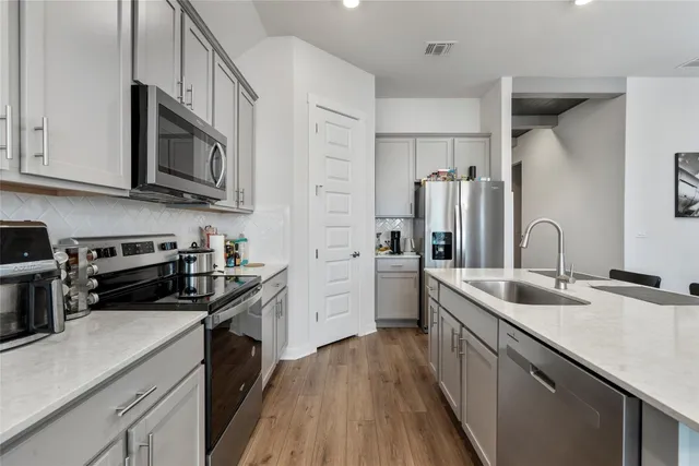 a kitchen with stainless steel appliances granite countertop a sink stove and refrigerator