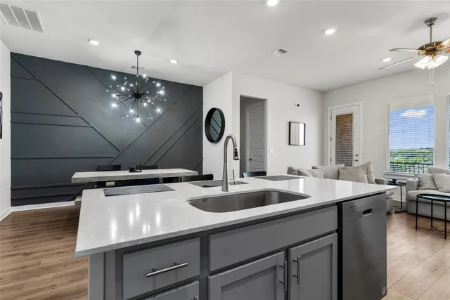 a room with kitchen island stainless steel appliances a sink and living room view