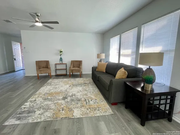 a living room with furniture and a wooden floor