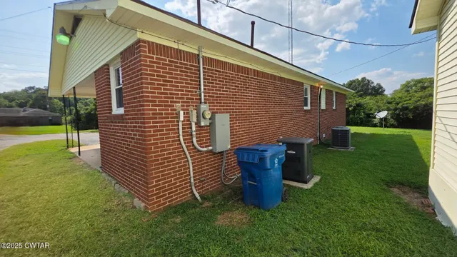 a backyard of a house with wooden fence and a bench