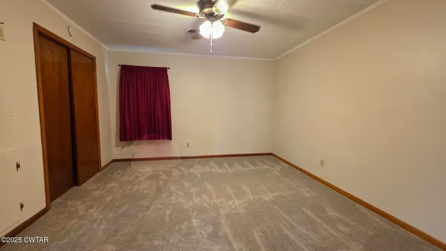 a view of an empty room with a ceiling fan