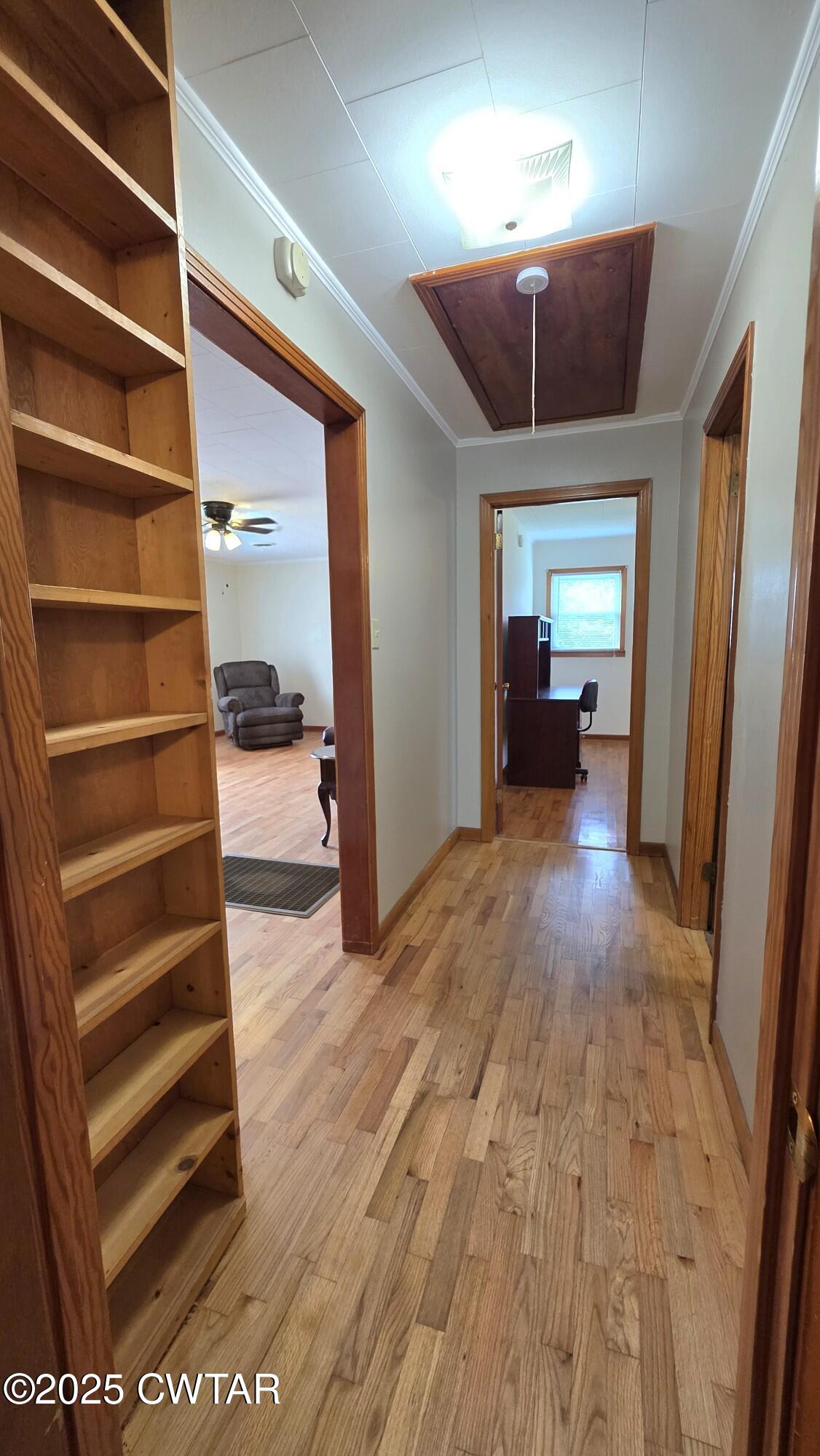 811 Gibson Road Trenton, TN 38382 - Photo 8 of 23 a view of a hallway with wooden floors and a fireplace