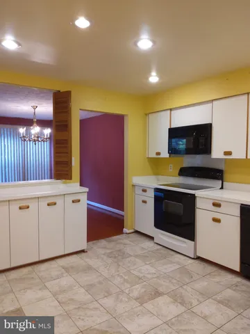 a kitchen with granite countertop a stove a sink and a microwave