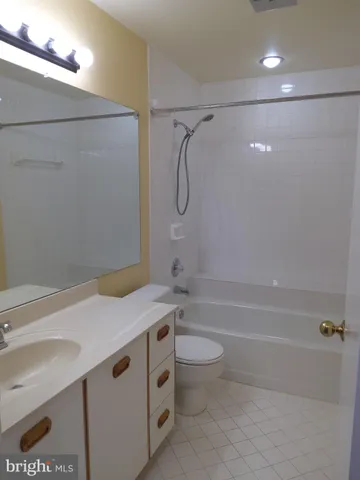 a bathroom with a granite countertop sink a toilet and shower