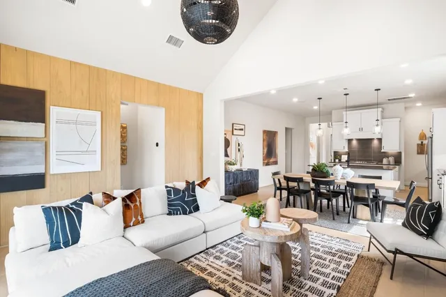 a living room with furniture kitchen view and a table