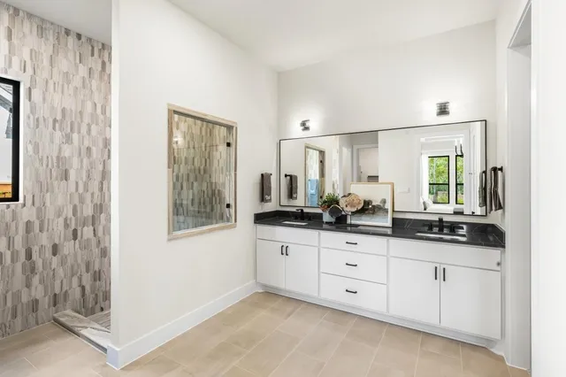 a bathroom with double sink and a mirror