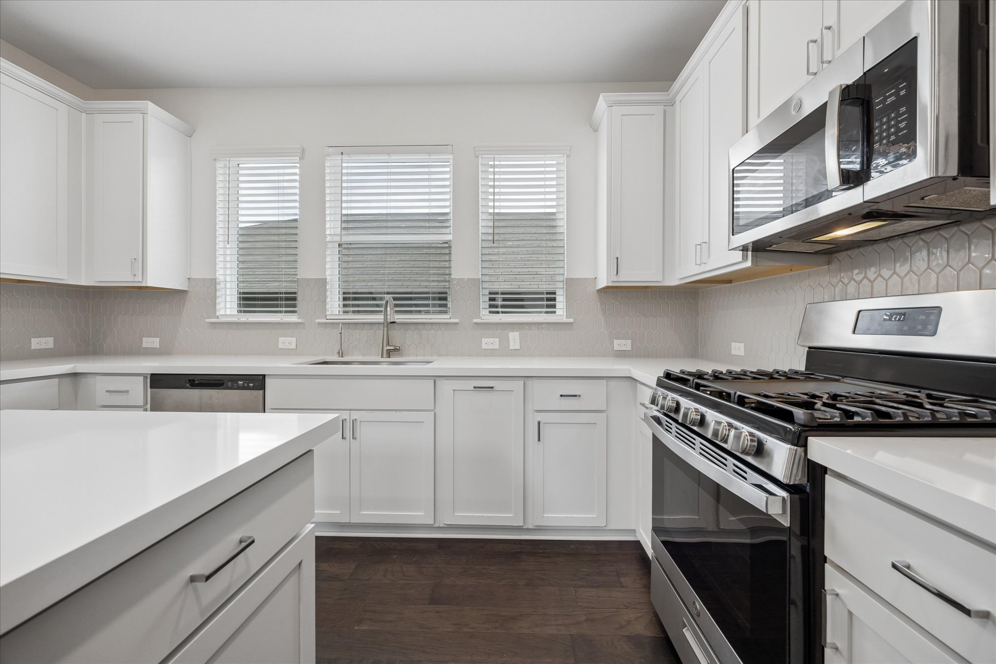 6407 Rounded Pebble Lane Buda, TX 78610 - Photo 12 of 32 A pristine culinary space features gleaming countertops and modern appliances, perfect for everyday living.