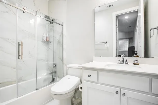 a bathroom with a sink toilet vanity and shower