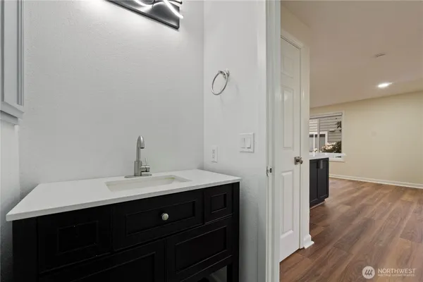 a spacious bathroom with a double vanity sink a mirror and wooden floor