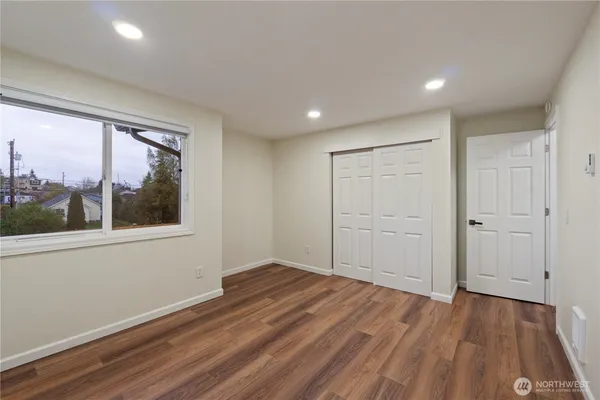 a view of a room with wooden floor and window