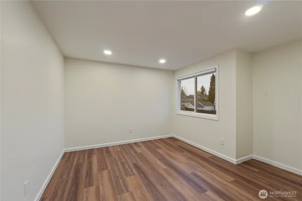 a view of a room with wooden floor and window