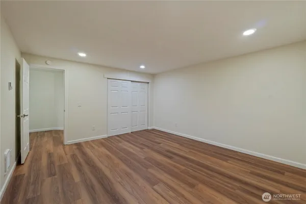a view of empty room with wooden floor