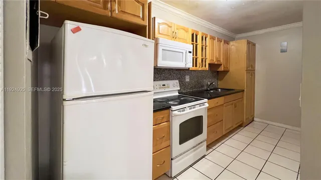a kitchen with granite countertop a sink and a refrigerator