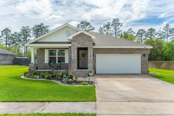 a front view of a house with a garden and yard