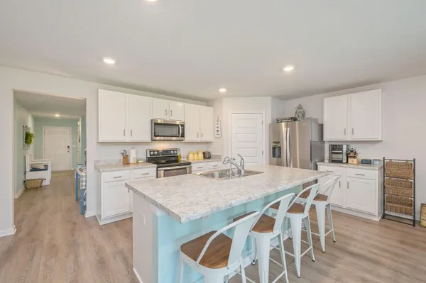 a kitchen with stainless steel appliances granite countertop a stove a sink and a refrigerator