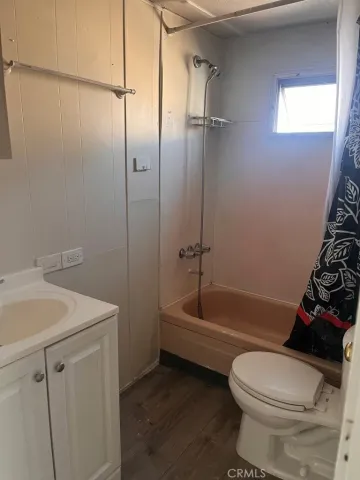 an empty room with wooden floor and windows in it