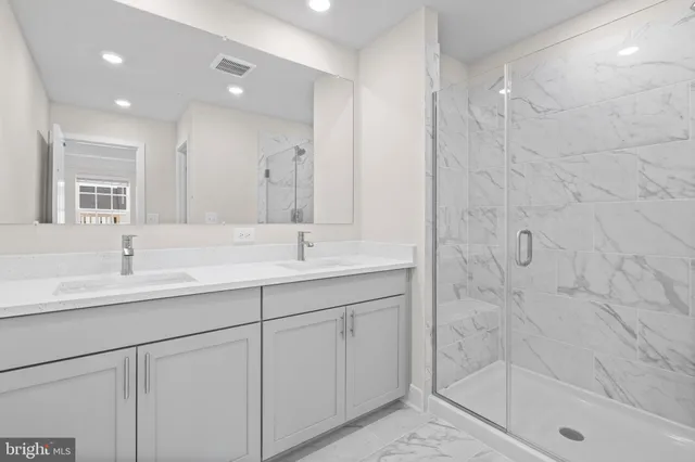 a bathroom with a shower sink and mirror